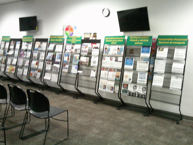 Racks of various resources with two tv and a clock on top of it.